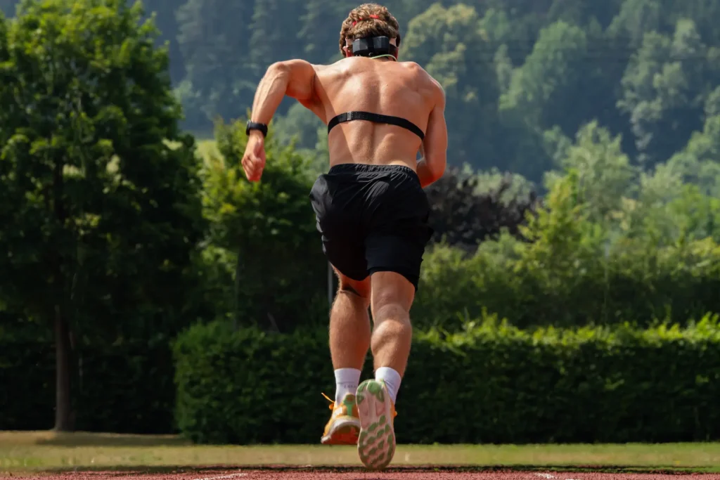 Runner on an outdoor track wearing SpiroFit headgear and a heart rate chest strap