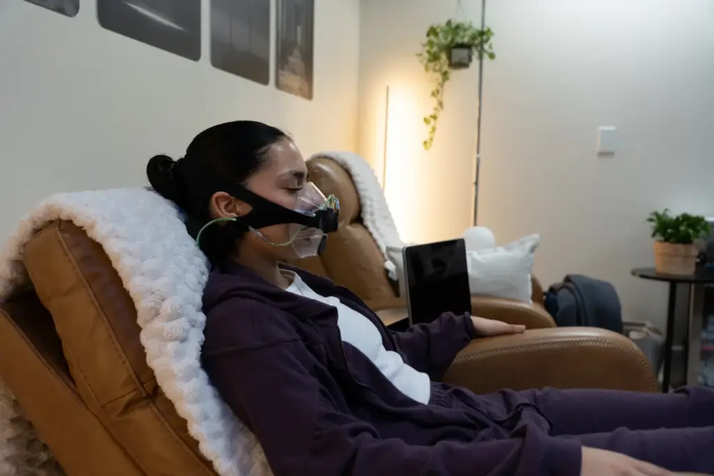 Woman reclining in a chair during a resting metabolic rate test with a SpiroFit mask